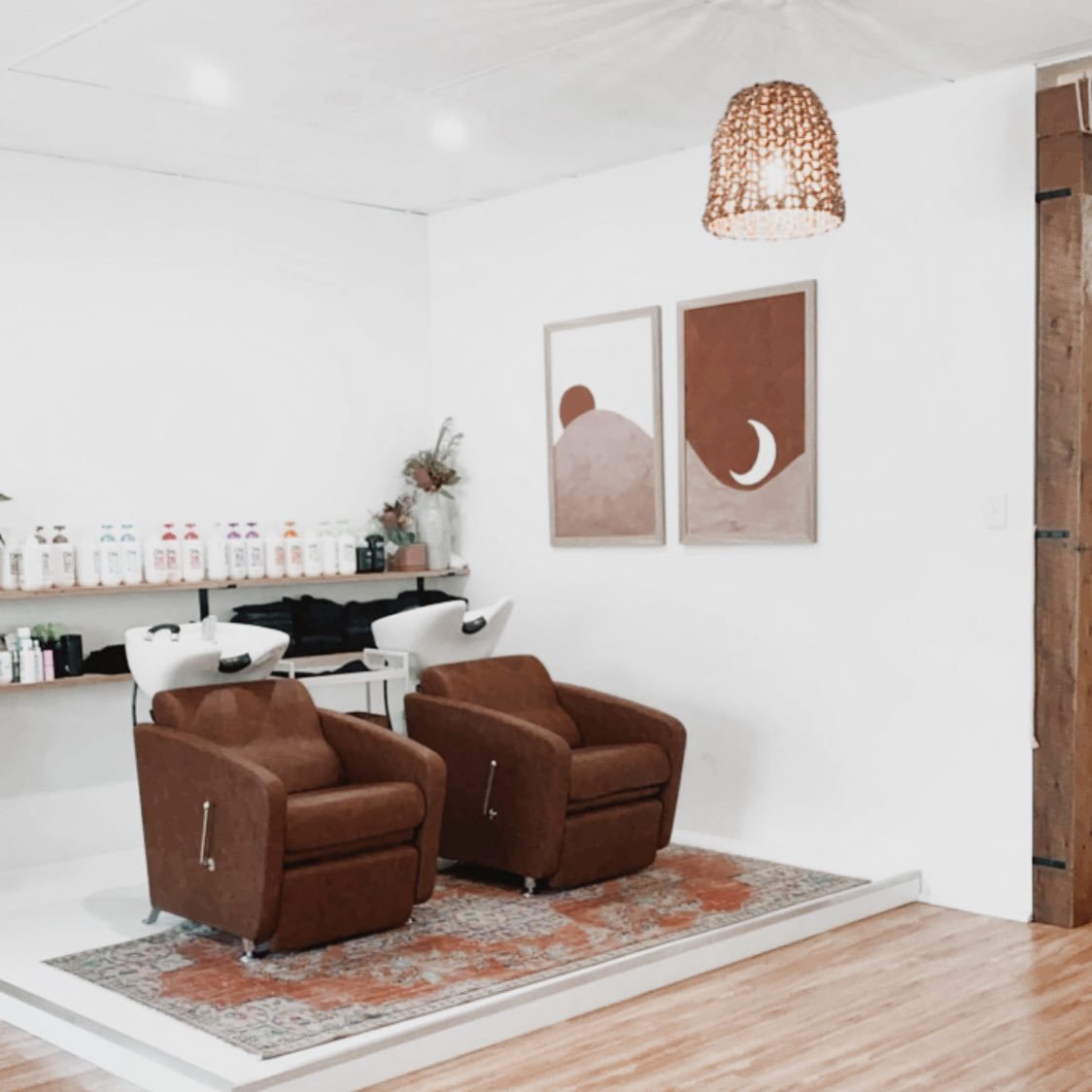 Two basin chairs on a raised platform under a rattan pendant, from the salon’s earlier Barber Street rooms