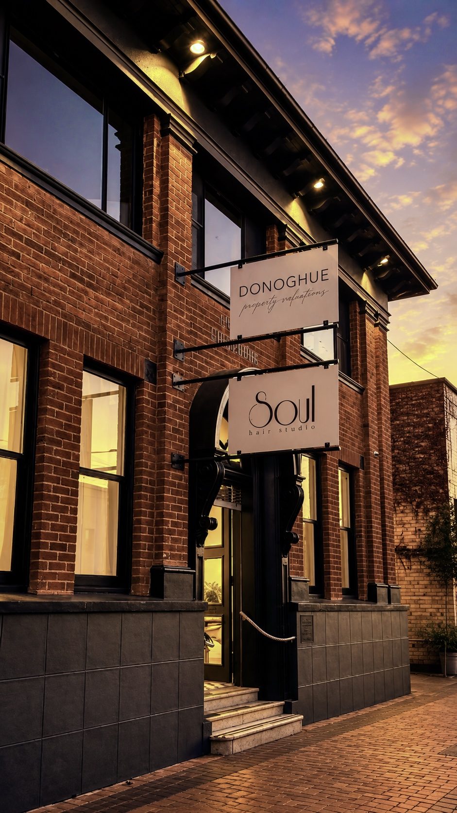 The salon shopfront at dusk, warm light through the arched doorway and the Soul hair studio blade sign above